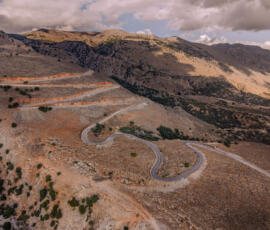 Serpentines leading through Crete’s southern landscape. Aerial view of a curving mountain road near Agios Galini on Crete.